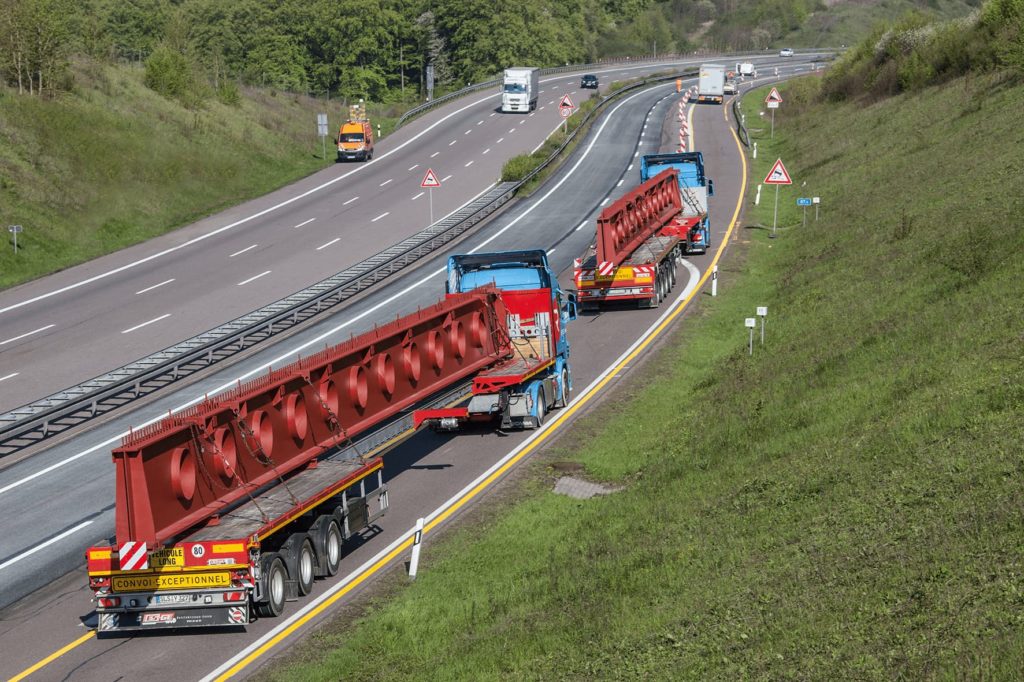 Rein Spedition Saarland_zwei LKW auf der Autobahn mit sehr langen Bauteilen auf der Ladefläche _ Teleskopanhänger