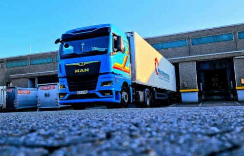 Kühlauflieger_vor Laderampe Kühlauflieger und blaue Sattelzugmaschine_der Rein Spedition_vor einem Lager an einer Laderampe